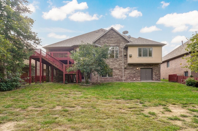 rear view of house featuring a lawn, stairs, fence, a wooden deck, and stucco siding