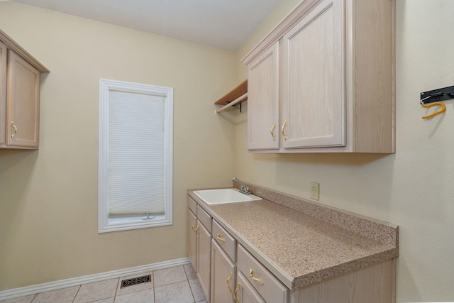 laundry area with light tile patterned floors, baseboards, visible vents, and a sink