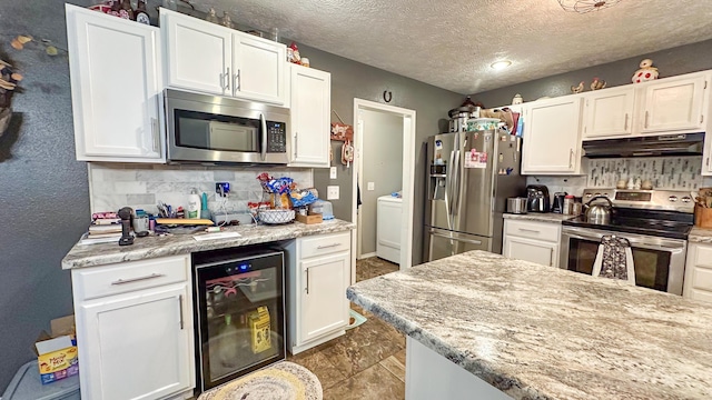 kitchen featuring beverage cooler, appliances with stainless steel finishes, white cabinets, and under cabinet range hood