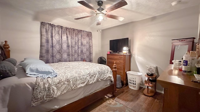 bedroom with a textured ceiling, wood finished floors, a ceiling fan, and baseboards