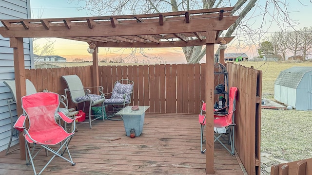 deck with an outbuilding, fence, a storage unit, and a pergola