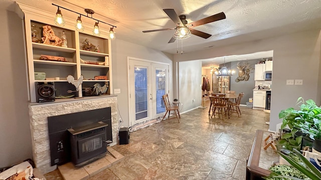 living room featuring a textured ceiling, ceiling fan, french doors, and baseboards