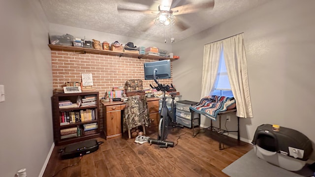 office featuring a ceiling fan, a textured ceiling, baseboards, and wood finished floors