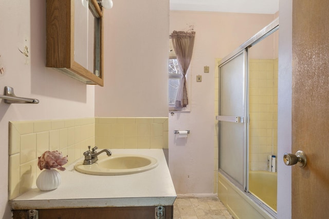 full bathroom featuring enclosed tub / shower combo, backsplash, and vanity