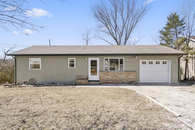 ranch-style house featuring roof with shingles, dirt driveway, an attached garage, entry steps, and stone siding