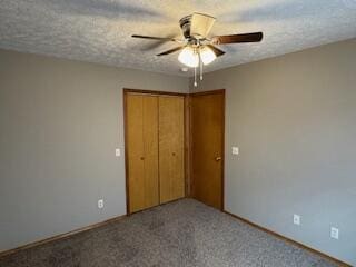 unfurnished bedroom featuring a textured ceiling, carpet floors, a closet, and a ceiling fan