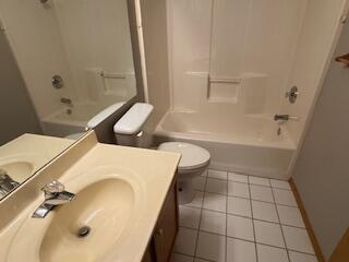 full bathroom featuring bathtub / shower combination, vanity, toilet, and tile patterned floors