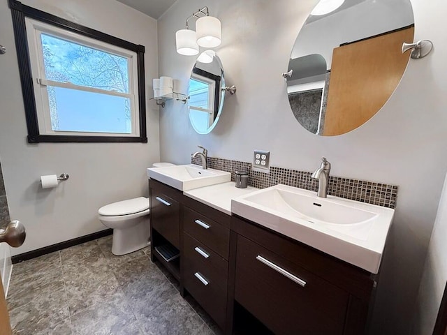 full bath featuring toilet, double vanity, backsplash, and a sink