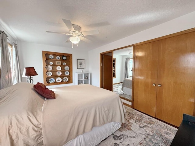 bedroom with ceiling fan, a textured ceiling, and a closet