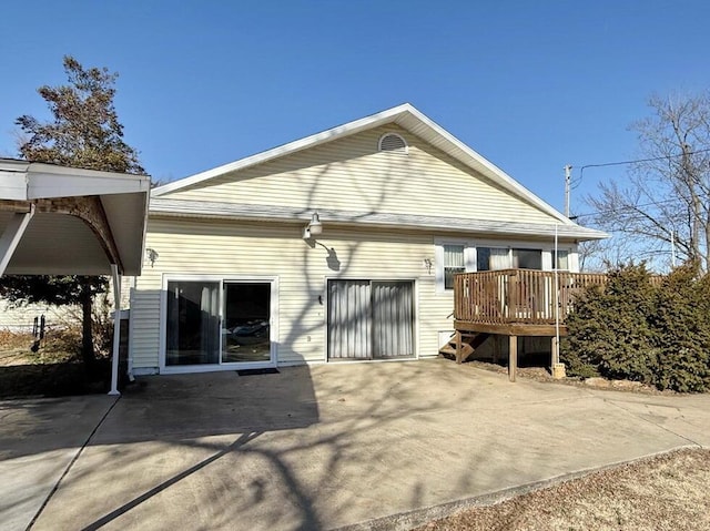 back of house with a deck, concrete driveway, and an attached garage