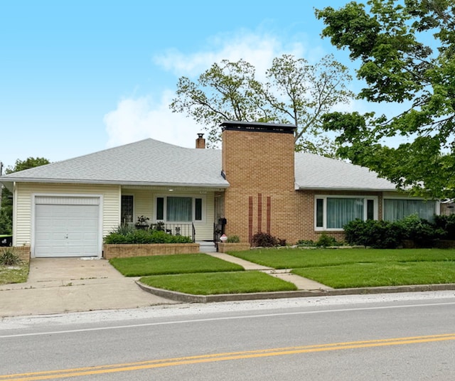 ranch-style home featuring an attached garage, a chimney, driveway, and a front yard