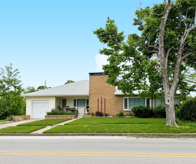 ranch-style house with a garage, driveway, a front lawn, a chimney, and brick siding