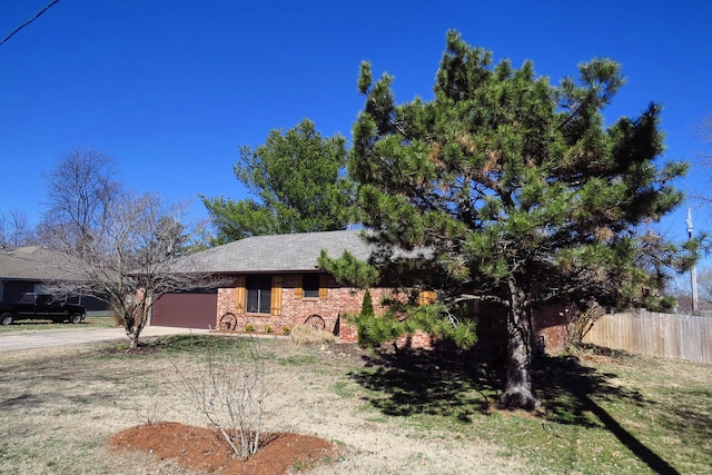 view of front of property with an attached garage, fence, concrete driveway, and brick siding