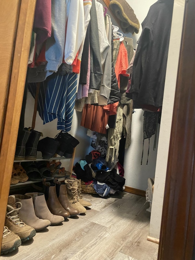 walk in closet with wood finished floors