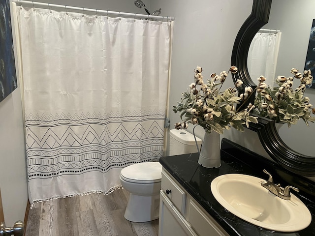 full bathroom featuring curtained shower, vanity, toilet, and wood finished floors