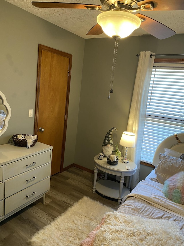 bedroom featuring a ceiling fan, a textured ceiling, and light wood finished floors