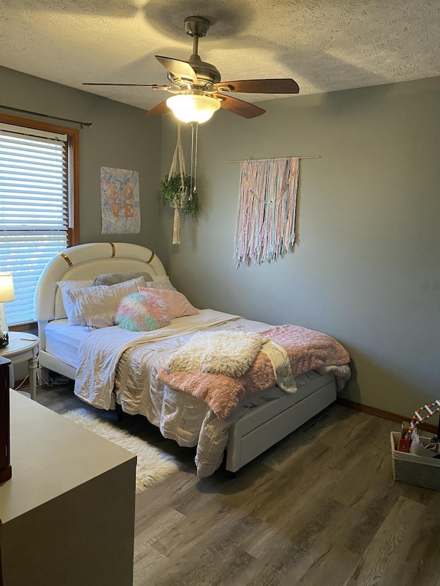 bedroom featuring a textured ceiling, wood finished floors, and a ceiling fan