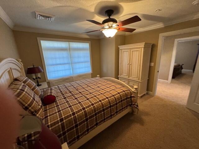 bedroom featuring light carpet, baseboards, visible vents, ornamental molding, and a textured ceiling