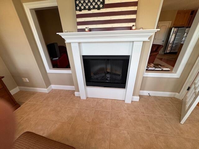 interior details featuring baseboards and a glass covered fireplace