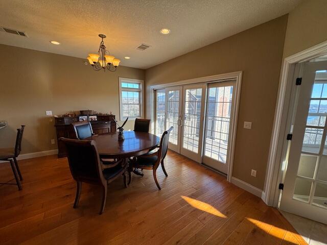 dining room featuring vaulted ceiling, french doors, wood finished floors, and visible vents