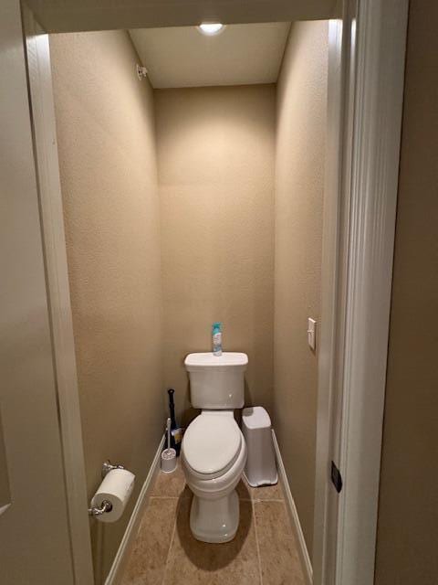 bathroom featuring toilet, tile patterned flooring, and baseboards