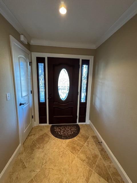 entrance foyer featuring baseboards and ornamental molding