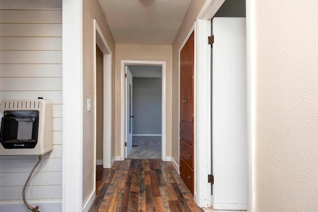 hallway with wood-type flooring, baseboards, a textured wall, and heating unit