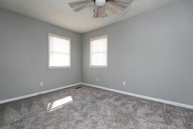 carpeted spare room with ceiling fan, visible vents, and baseboards