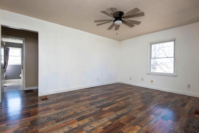 spare room with dark wood-style floors, baseboards, and a ceiling fan