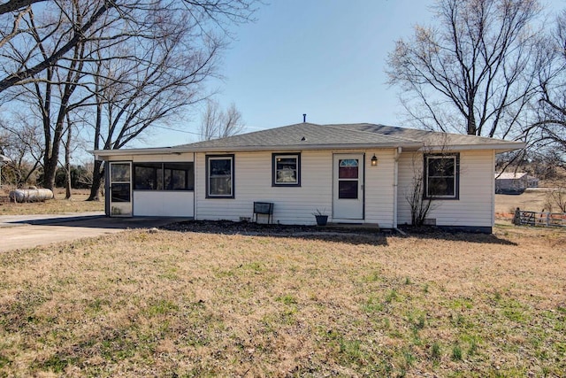 ranch-style home with a front yard, a sunroom, and driveway