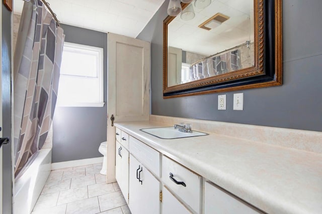 bathroom featuring baseboards, toilet, tile patterned flooring, shower / bath combo with shower curtain, and vanity