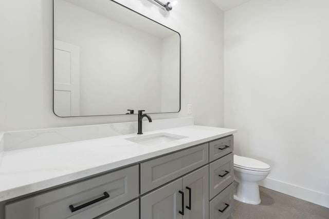 bathroom with toilet, baseboards, and vanity