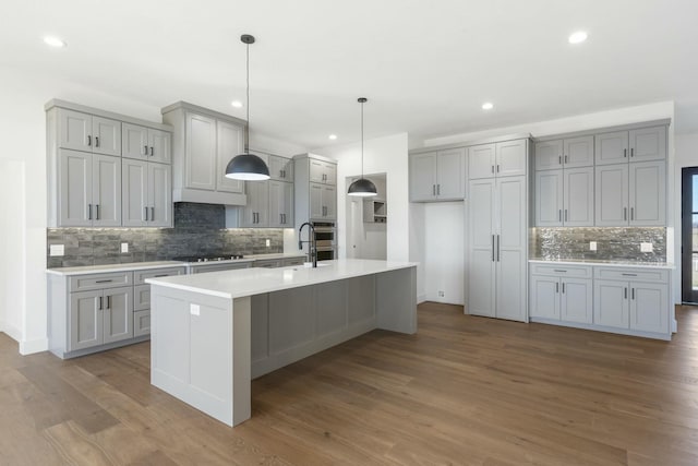 kitchen with gas stovetop, wood finished floors, and gray cabinetry