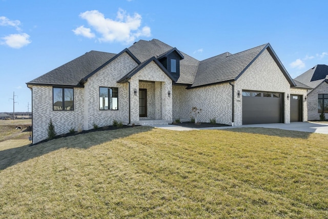 french country style house with brick siding, roof with shingles, concrete driveway, an attached garage, and a front yard