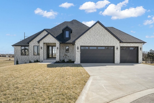 view of front of property with a garage, a shingled roof, concrete driveway, a front yard, and brick siding