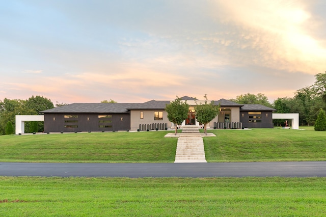 prairie-style house with stucco siding and a yard