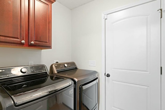 laundry room with cabinet space and washer and clothes dryer