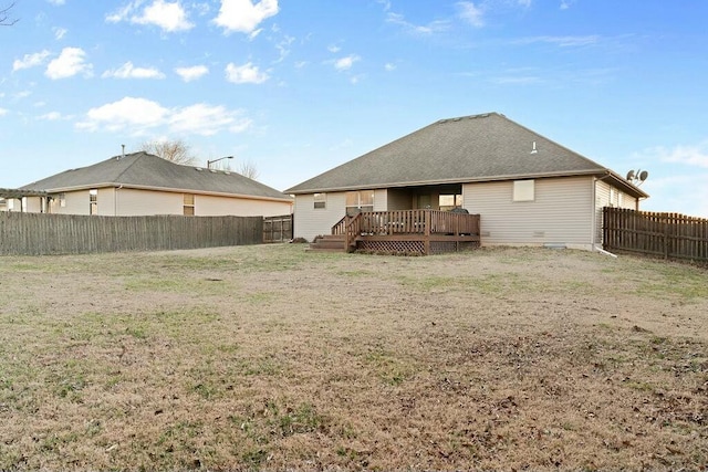 back of house featuring a fenced backyard, a yard, a deck, and roof with shingles