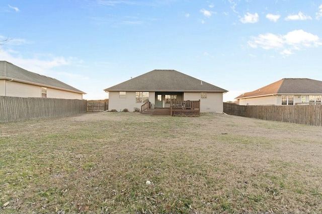 back of house featuring a yard, a fenced backyard, and a wooden deck