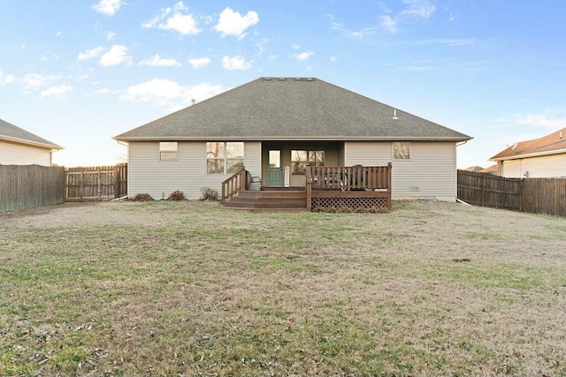 rear view of property with a fenced backyard, a lawn, a deck, and roof with shingles