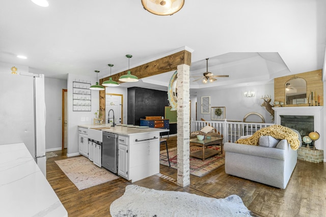 kitchen featuring dark wood-style flooring, light countertops, freestanding refrigerator, dishwasher, and a peninsula