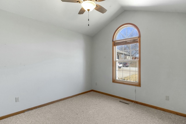 spare room with lofted ceiling, baseboards, visible vents, and light colored carpet