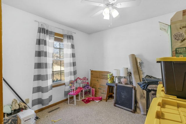 rec room with carpet floors, visible vents, ceiling fan, and baseboards