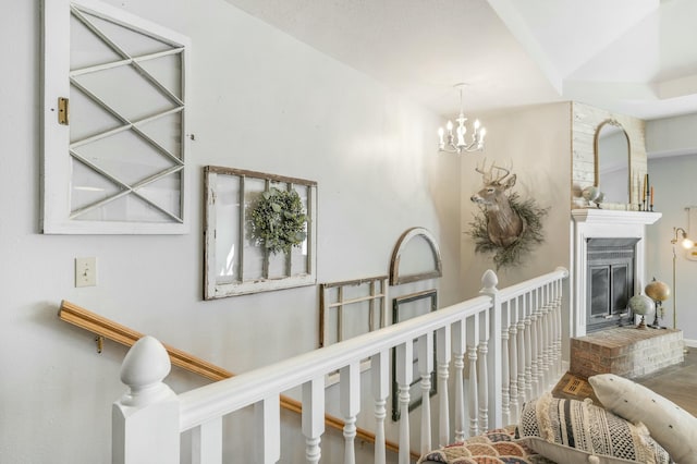 hallway with a notable chandelier and an upstairs landing