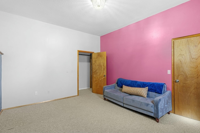 living area with a textured ceiling, carpet floors, and baseboards