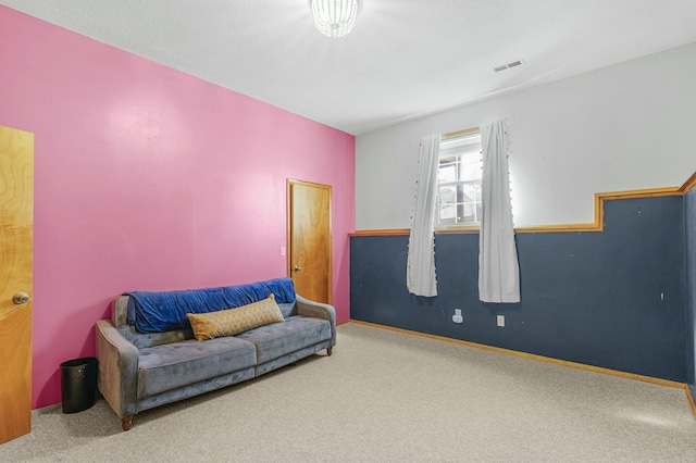 carpeted living area with baseboards and visible vents