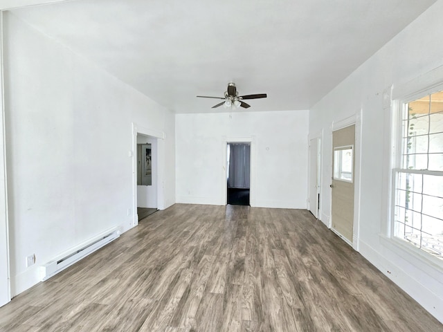 interior space featuring a baseboard heating unit, wood finished floors, a ceiling fan, and baseboards