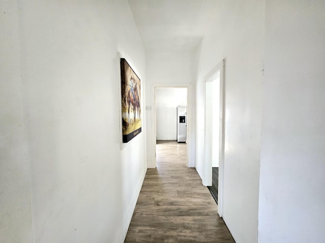 hall featuring baseboards and dark wood-style flooring