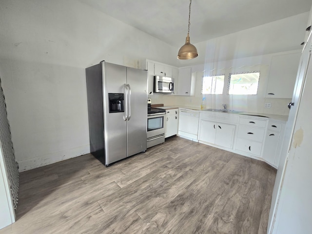 kitchen with light countertops, appliances with stainless steel finishes, wood finished floors, and white cabinets