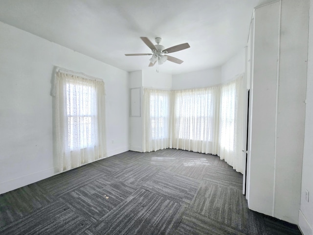 spare room with a ceiling fan, carpet flooring, and baseboards